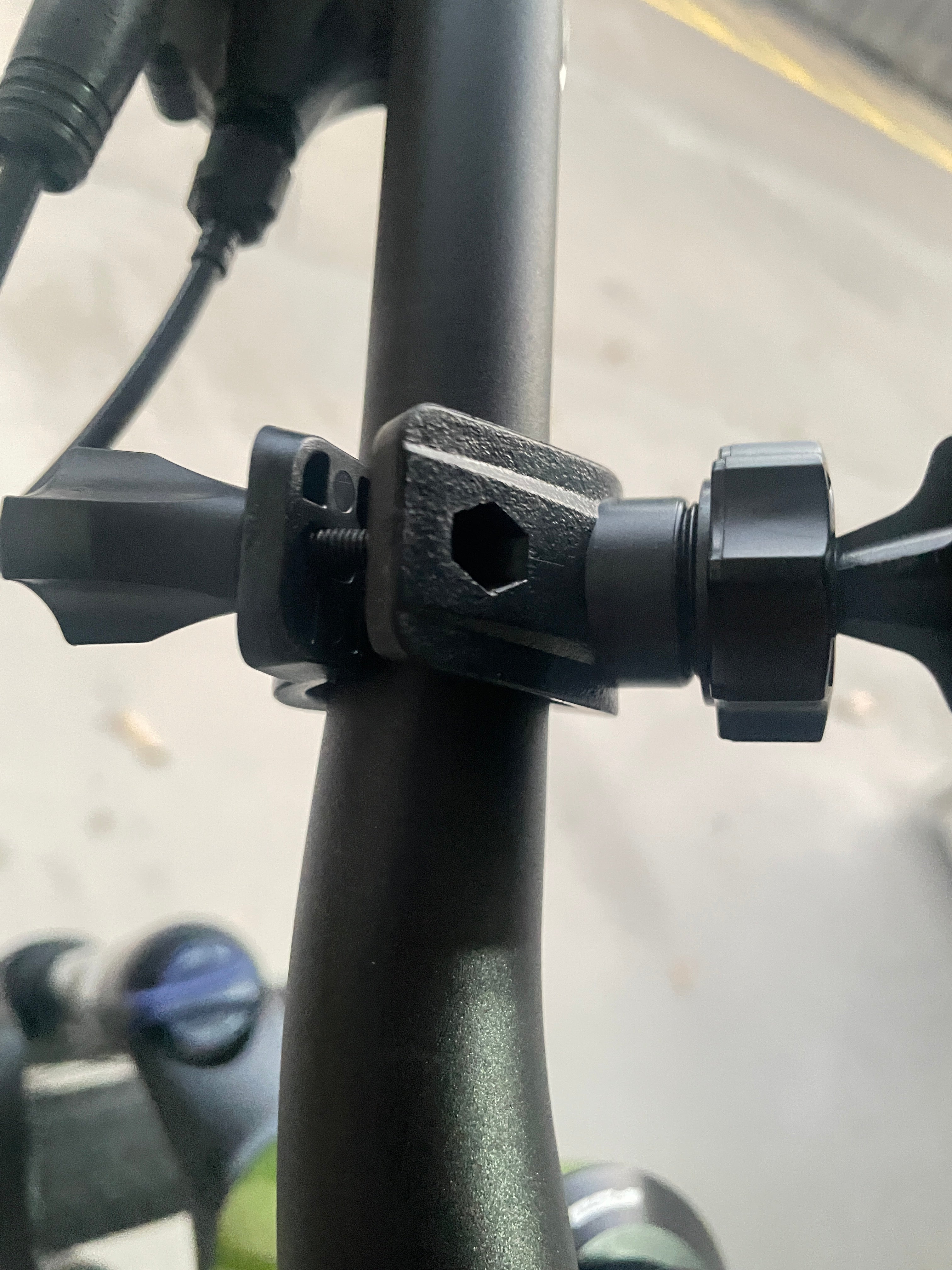 Close-up of a black metal clamp on a bike frame with a blurred background