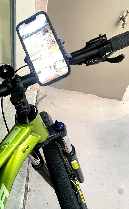 QENTROVA universal phone holder mounted on a mountain bike handlebar, securely holding a smartphone.